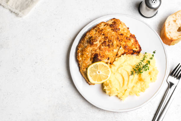 Schnitzel or breaded chop with mashed potatoes German schnitzel with fresh mashed potatoes on white background, copy space. Homemade breaded pork meat chop. Wiener Schnitzel. milanese cutlet stock pictures, royalty-free photos & images