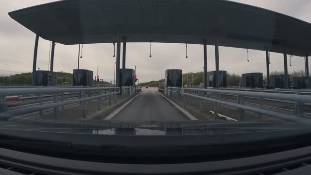 Driving through a toll booth or payment facility on a highway.