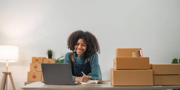 istock Startup small business SME, Entrepreneur owner woman using smartphone or tablet taking receive and checking online purchase shopping order to preparing pack product box. 1489367385