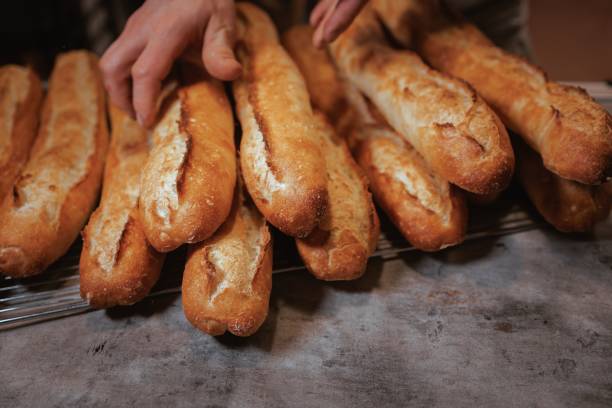 istock Baker working in the kitchen, preparing loaves of bread 1489370140