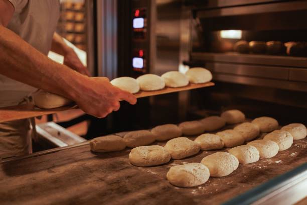 istock Baker working in the kitchen, preparing loaves of bread 1489370163