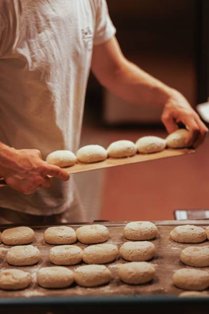istock Baker working in the kitchen, preparing loaves of bread 1489370238