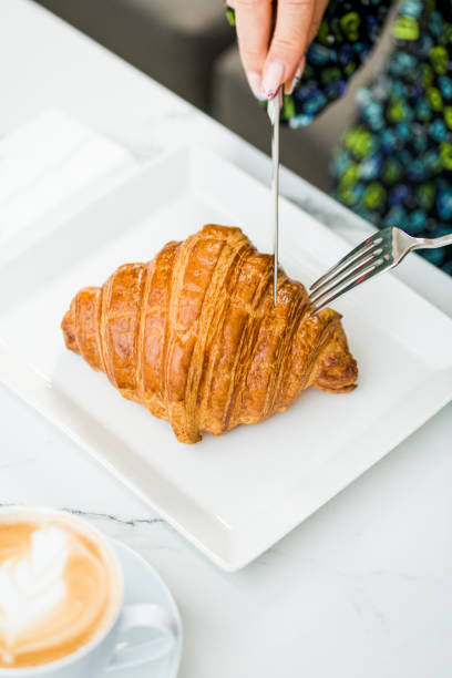 istock Croissant on a white porcelain plate with coffee on the side 1489370975