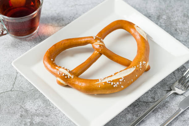 istock Pretzel in white porcelain plate on stone background 1489371881