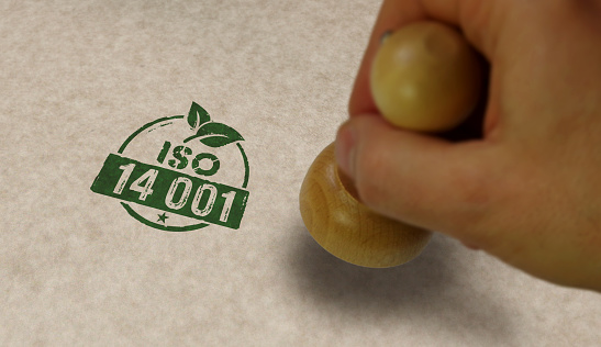 ISO 14001 certified stamp and stamping hand. Environment ecology standard certificate concept.
