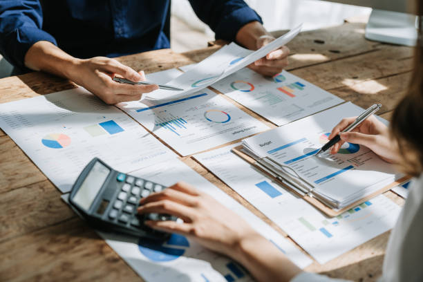 istock Two business people meeting to talking or discuss marketing work in workplace using paperwork, calculator, computer to work 1489380386