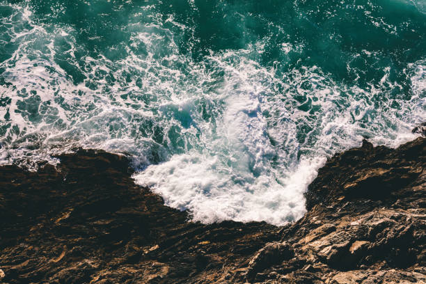 istock Waves crash and splash on rocks aerial top view 1489381564