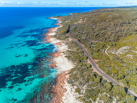 Aerial view of sandy coastal beach road. Sunny day in summer with transparent tropical blue water. Travel to Eagle Bay Meelup Road, Western Australia, Australia. Top view. Coastal, Seascape