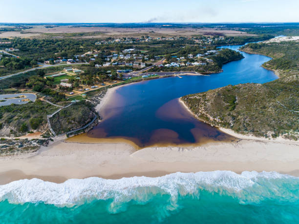 Aerial view looking back at the Western Australian town of Guilderton, where the river meets the sea. Vibrant river meet's turquoise sea waves on beach in Western Australian town called Guilderton. Seascape background. Coastal wallpaper. vista aérea mirando hacia atrás a la ciudad de guilderton, en australia occidental, donde el río se encuentra con el mar. el vibrante río se encuentra con las olas de mar turquesas en la playa de la ciudad de australia occidental llamada guilderton. fo