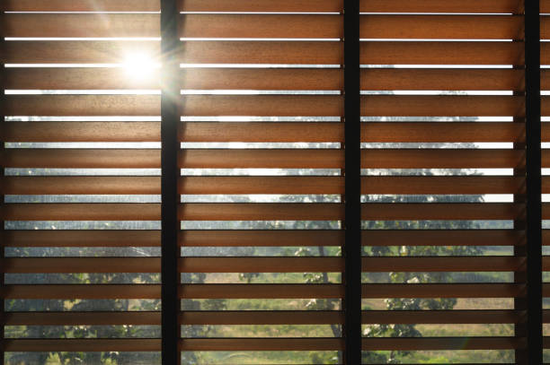 istock Close-up brown wooden blinds. lighting range control sunlight coming from a window. decoration interior. Modern jalousie. 1489383468
