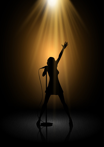 Silhouette of a female singer under spotlights