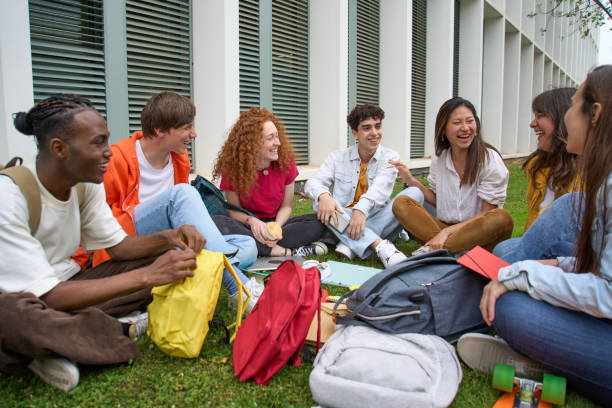 istock Group cheerful students gathered together outdoors. Multiracial college classmates enjoy recreation. 1489385080