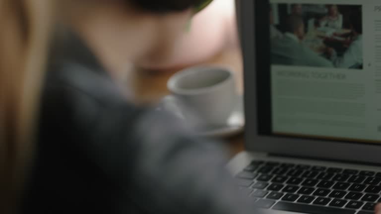 young business woman using laptop computer in cafe sharing business ideas on social media typing email drinking coffee enjoying lifestyle blogging listening to music