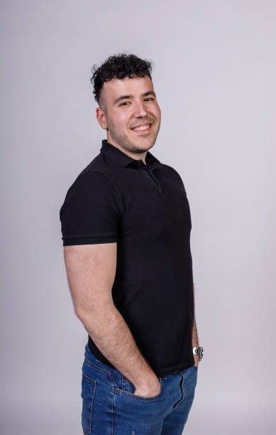 istock Confident young man standing against white background, smiling 1489389032