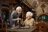Polite senior man holding his wife for a hand in a restaurant.
