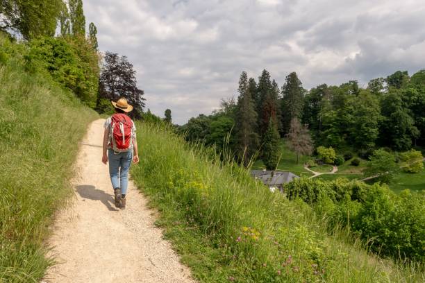 istock With a backpack and a straw hat hiking on a path surrounded by lush green grass 1489391896