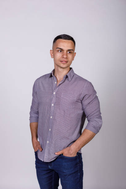 istock Confident young man standing against white background, smiling 1489392649