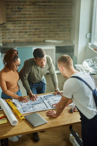 istock African American couple analyzing plans with their manual worker. 1489393873