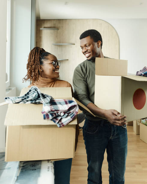 istock Happy black couple talking while carrying boxes in a new apartment. 1489394292