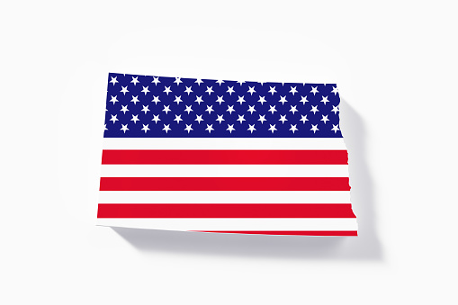 State border of North Dakota textured with American flag on white background. Horizontal composition with copy space.