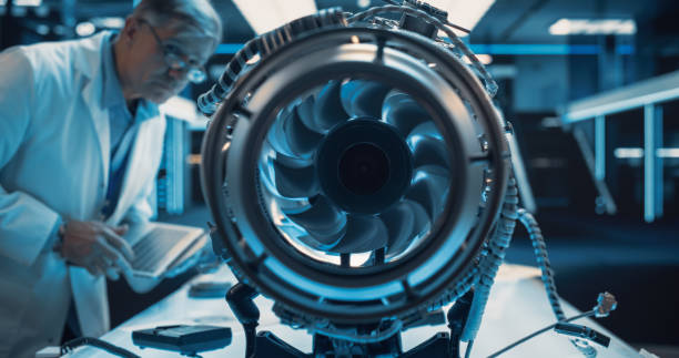 istock Middle Aged Industrial Turbine Specialist Working on an Innovative Invention. Scientist Using a Laptop Computer to Develop a High Tech Prototype Electric Jet Motor 1489394877