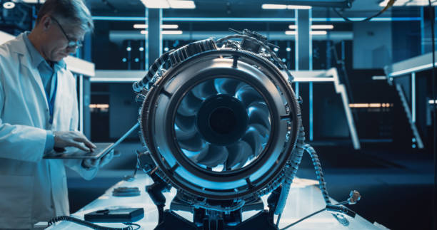 Middle Aged Industrial Turbine Specialist Working on an Innovative Invention. Scientist Using a Laptop Computer to Develop a High Tech Prototype Electric Jet Motor