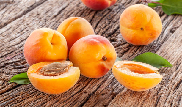 istock Ripe apricots on old wooden table. 1489396456