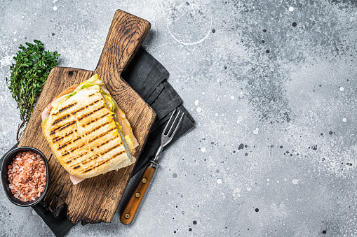 Toasted Panini sandwich with Prosciutto ham and cheese. Gray background. top view. copy space.