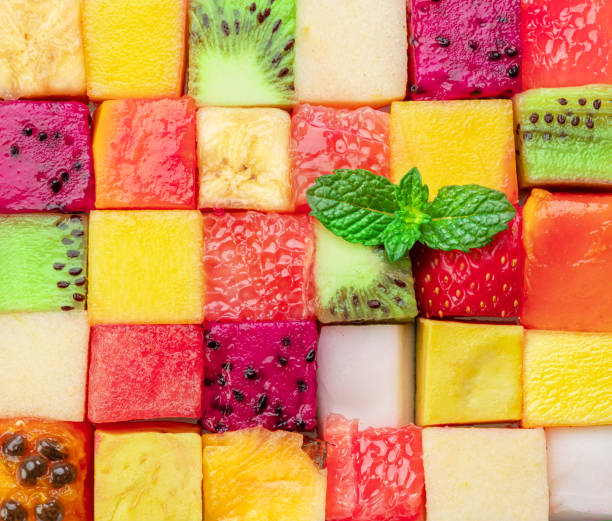 istock Fruit puzzle. Colorful food background or pattern arranged of different fruit cubes. Dietary concept. 1489397544