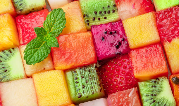 istock Fruit puzzle. Colorful food background or pattern arranged of different fruit cubes. Dietary concept. 1489397614
