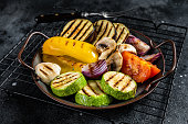 Grilled vegetables, bell pepper, zucchini, eggplant, onion and tomato. Black background. Top view