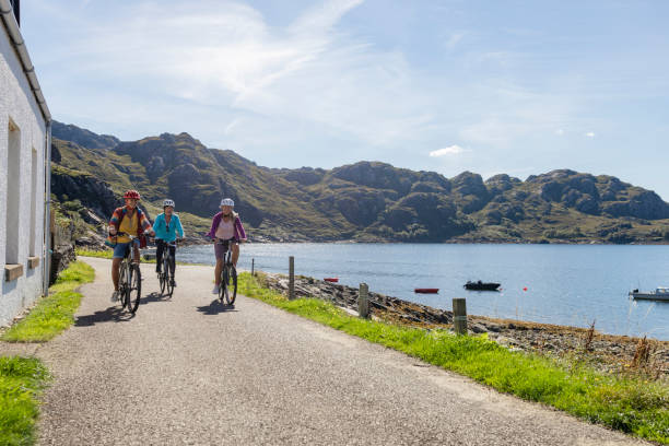 Friends at the bay near the village of Diabaig on the side of Loch Torridon in Wester Ross, Scotland. They are on a bike ride together, having fun along the waters edge.