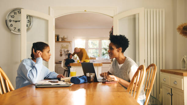 istock Mother with laptop talking to daughter doing homework 1489400858