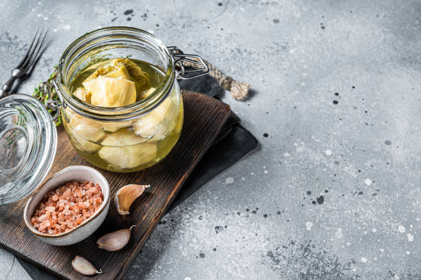 istock Artichoke hearts marinated in olive oil. Gray background. Top view. Copy space 1489401594