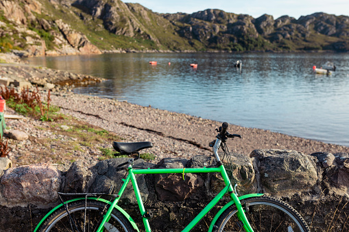 Bike leaning against a wall near the village of Diabaig on the side of Loch Torridon in Wester Ross, Scotland.