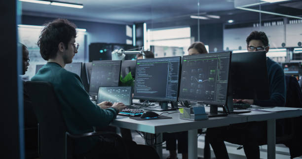 istock Group of Empowered Multicultural Men and Women Working in a Research Center, Using Computers to Run Advanced Software, Develop Artificial Intelligence Interface and Neural Network Blockchain 1489403609