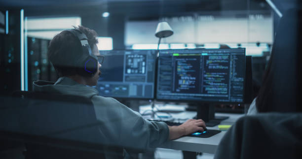 istock Team of Talented Young Professionals Working in a Technological Research and Development Agency. Computer Screens with Software Code and Technical Neural Network Diagrams 1489404387