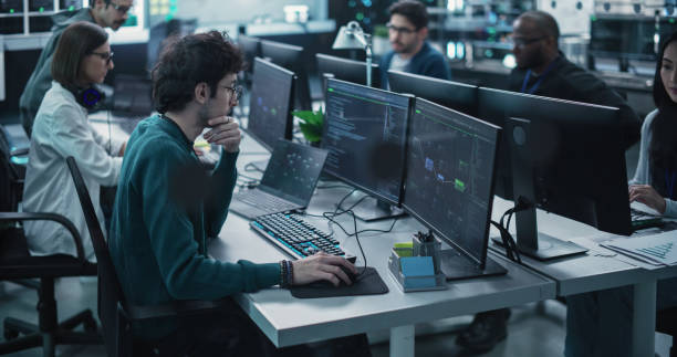 istock Team of Talented Young Professionals Working in a Technological Research and Development Facility. Diverse Specialists Using Computers, Writing Code, Planning Innovative Information Technology Project 1489404479