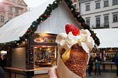 Trdelnik, typical Czech dessert, with cream and strawberry, Old Town Square in Prague