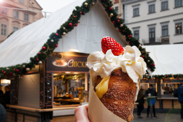 Trdelnik, typical Czech dessert, with cream and strawberry, Old Town Square in Prague Trdelnik, typical Czech dessert, with cream and strawberry, Old Town Square in Prague trdelník stock pictures, royalty-free photos & images