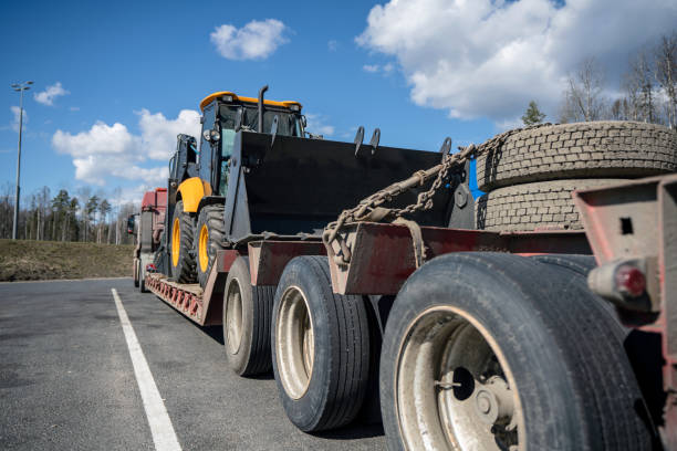 istock Tractor on the trailer of a construction machinery transporter 1489407911