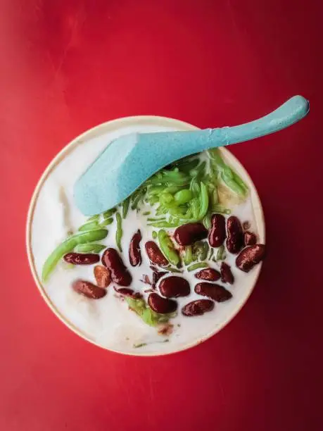 A Malaysian traditional iced sweet dessert Cendol served in a bowl with coconut milk and red beans.