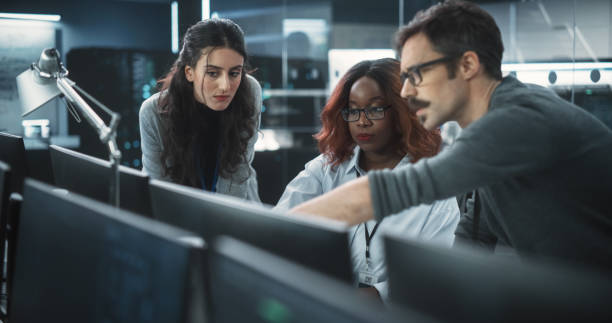 istock Group of Empowered Multicultural Specialists Working in a Research Center, Using Computer to Collaborate on Advanced Software, Develop Artificial Intelligence Interface and Cloud-Based Blockchain 1489412835
