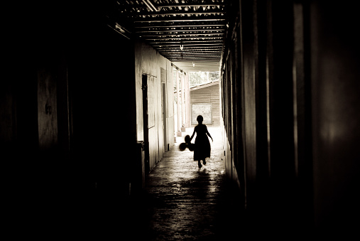 little girl silhouette in dirty alley with balloons