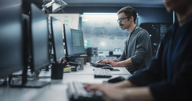 istock Portrait of a Thoughtful Engineer Working on Desktop Computer in a Technological Office Environment. Research and Development Department Writing Software Code for an Innovative Internet Project 1489413799