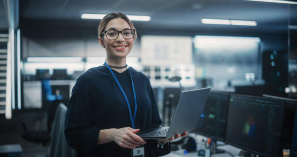 retrato de uma mulher multiétnica empoderada atraente olhando para a câmera e sorrindo encantadoramente. empresária no trabalho, gerente de tecnologia da informação, profissional de engenharia de software - data center computer programmer women - fotografias e filmes do acervo