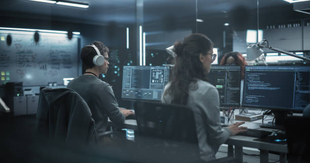 istock Team of Talented Young Professionals Working in a Technological Research and Development Agency. Computer Screens with Software Code and Technical Neural Network Diagrams 1489414606