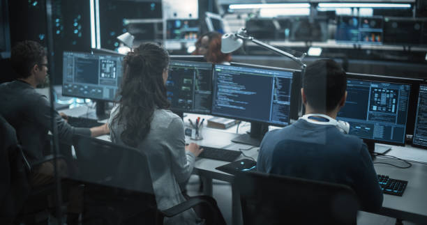 istock Team of Talented Young Professionals Working in a Technological Research and Development Agency. Computer Screens with Software Code and Technical Neural Network Diagrams 1489414641