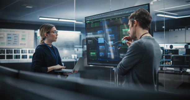 istock Two Diverse Software Developers Having a Meeting in a Conference Room. Female and Male Tech Industry Engineers Brainstorming Ideas for Their Neural Network Blockchain Startup 1489415029