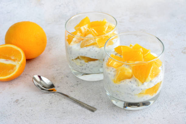 istock Two glasses of orange chia pudding with a spoon on a white table, close-up 1489416585